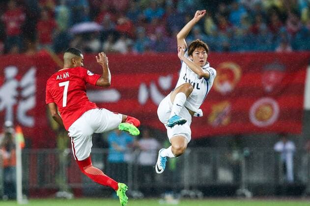 Alan Douglas Borges de Carvalho of China s Guangzhou Evergrande, left, challenges Shoma Doi of Japan s Kashima Antlers during their first Round of 16 match of the AFC Champion League 2017 in Guangzhou city, south China s Guangdong province, 23 May 2017. Guangzhou Evergrande defeated Kashima Antlers 1-0. Paulinho helps Guangzhou beat Kashima in first Round of 16 at AFC Champions League  20170523_35735