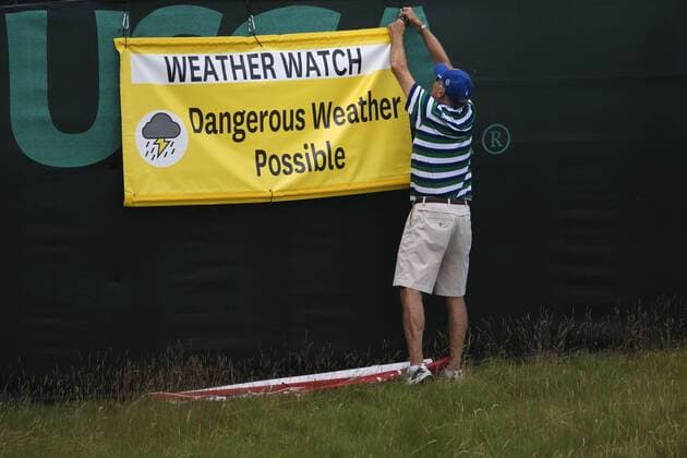 170614 En funktionär sätter upp en skylt som varnar för ett oväder som drar in över golfbanan Erin Hills inför golfturneringen US Open den 14 juni 2017 i Hartford.  Copyright: JOELxMARKLUND BB170614JM033