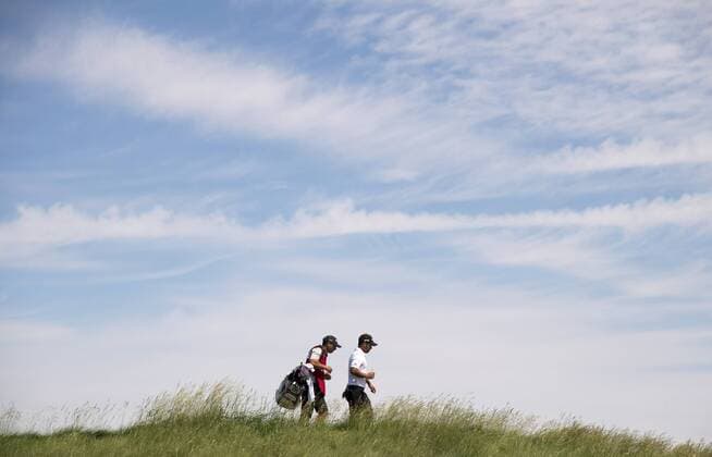 Xander Schauffele and his caddie Austin Kaiser walk on the 8th fairway during round 2 of the 117th U.S. Open golf tournament at Erin Hill golf course in Erin, Wisconsin on June 16, 2017.  WIS20170616329 KEVINxDIETSCH