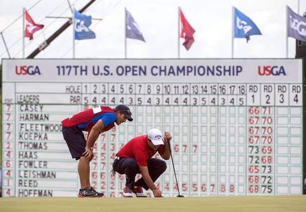 Patrick Reed and his caddie Kessler Karain line up a putt on the 18th green during round 3 of the 117th U.S. Open golf tournament at Erin Hill golf course on June 17, 2017 in Erin, Wisconsin.  WIS20170617304 KEVINxDIETSCH
