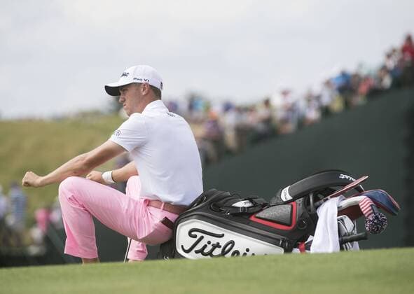 Justin Thomas sits on his bag as he waits to putt on the 18th green during round 3 of the 117th U.S. Open golf tournament at Erin Hill golf course on June 17, 2017 in Erin, Wisconsin.  WIS20170617333 KEVINxDIETSCH