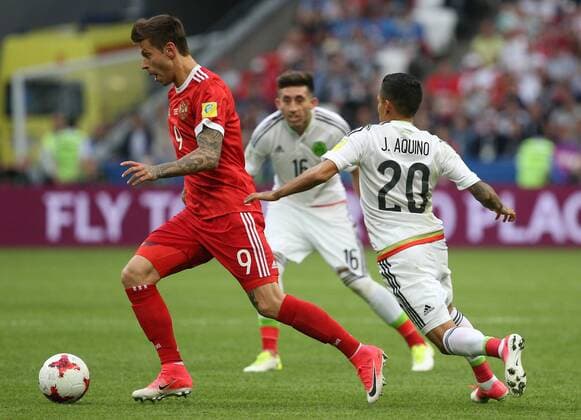 KAZAN, RUSSIA - JUNE 24, 2017: Russia s Fyodor Smolov (L), and Mexico s Javier Aquino (20) and Hector Herrera (C back) in action in their 2017 FIFA Confederations Cup First Stage Group A football match at Kazan Arena Stadium; Mexico won the game 2-1. Yegor Aleyev TASS  TS054A44