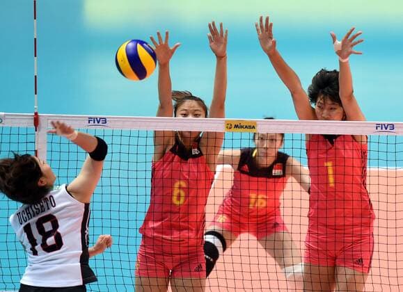 Gong Xiangyu, left, and Yuan Xinyue of China spike against Mami Uchiseto of Japan during the Pool G1-Group 1 match of the FIVB Volleyball World Grand Prix Hong Kong 2017 in Hong Kong, China, 21 July 2017. China defeated Japan 3-1 (25-19, 25-20, 33-35, 25-21). China defeats Japan during FIVB Volleyball World Grand Prix Hong Kong 2017  pbu656153_06