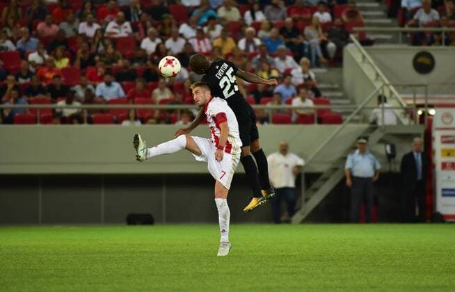 Greece: Olympiacos vs Partizan Kostas Fortounis (no 7) of Olympiacos and Everton Bilher (no 25) of Partizan vindicate the ball during the game.  DimitriosxKarvountzis PacificxPress