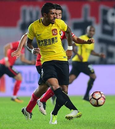 Brazilian football player Paulinho, left, of Guangzhou Evergrande kicks the ball to make a pass against a player of Liaoning Whowin in their 21st round match during the 2017 Chinese Football Association Super League (CSL) in Shenyang city, northeast China s Liaoning province, 10 August 2017. Guangzhou Evergrande competes against Liaoning Whowin at 21st round of 2017 CSL  20170810_07587