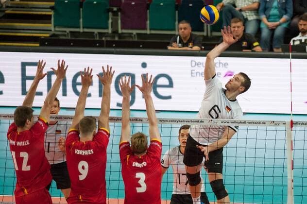v.li.: Gert van Walle (Belgien, 12), Pieter Verhees (Belgien, 9) und Sam Deroo (Belgien, 3) mit einem Block gegen den Ball von Denis Kaliberda (Deutschland, 6) spielt den Ball über das Netz, Volleyball, Länderspiel, Deutschland - Belgien, xobx
