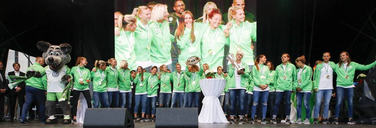 Mannschaft des VfL schaut auf Leinwand, wo Grußworte der Herrenmannschaft (hier Trainer Andries Jonker) eingeblendet werden., Fussball, Frauen, Ehrung des Doublesiegers VfL Wolfsburg, xtgx
