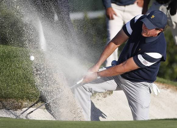Phil Mickelson of the United States hits out of a bunker on the 14th hole on day one of the Presidents Cup on September 28, 2017 at Liberty National Golf Club in Jersey City, New Jersey.  NYP20170928514 RICHxSCHULTZ