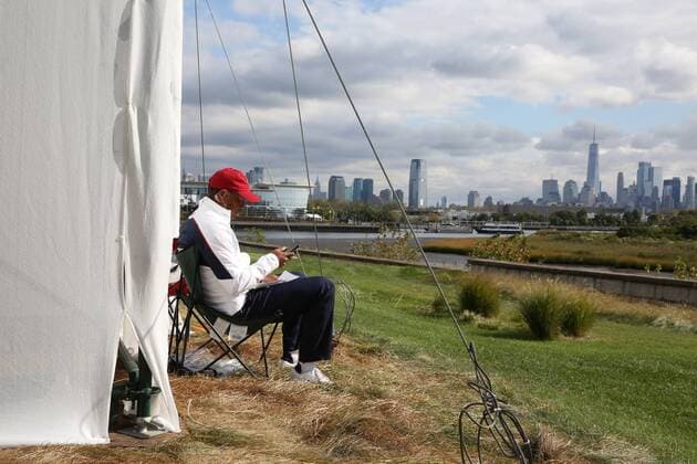 JERSEY CITY, NJ - SEPTEMBER 30: USA vice captain Tiger Woods sits down all by himself to rest on a volunteers chair behind the 13th grandstand with the New York city skyline in the background during the third round of the Presidents Cup at Liberty National Golf Club on September 30, 2017 in Jersey City, New Jersey. (Photo by Brian Spurlock Icon Sportswire) GOLF: SEP 30 PGA Golf Herren - The Presidents Cup - Third Round Icon170930244 EDITORIAL USE ONLY