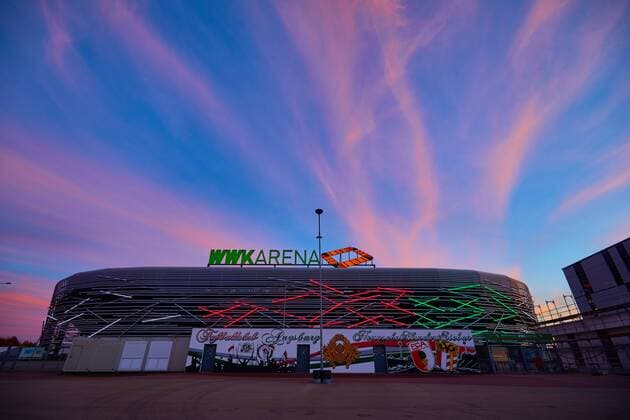 Fußball, Stadiongeschichte FC Augsburg WWK-Arena Augsburg, beleuchtete Fassade in Vereinsfarben Rot-Grün-Weiß; Nordseite,