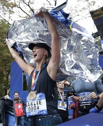 Super Model Karlie Kloss celebrates wearing her Marathon Medal after she crosses the finish line completing the NYRR TCS New York City Marathon in New York City on November 5, 2017. 50,000 runners from the Big Apple and around the world raced through the five boroughs on a course that winds its way from the Verrazano Bridge before crossing the finish line by Tavern on the Green in Central Park.  NYP20171105144 JOHNxANGELILLO