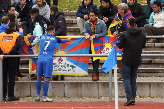 NECMI GUER SPRICHT MIT DEN TIBET INITIATIVE DEUTSCHLAND MIT TIBETFLAGGEN TSV SCHOTT MAINZ-CHINA U20 TESTSPIEL REGIONALLIGA SUEDWEST MAINZ 