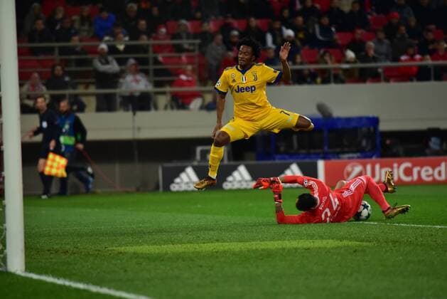 Greece: Champions League Olympiacos vs Juventus Silvio Proto (no 24) goalkeeper of Olympiacos,stops the effort of Juan Cuadrado (no 7) of Juventus. Athens Attiki Greece G. Karaiskakis Stadium  DimitriosxKarvountzis PacificxPress