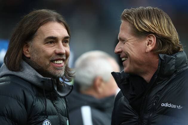 HAMBURG, GERMANY - December 09: Head coach Markus Gisdol (R) of Hamburg and Head coach Martin Schmidt (L) of Wolfsburg talks before the first bundesliga match between Hamburger Verein and VfL Wolfsburg at the Volksparkstadion on December 09, 2017 in Hamburg.