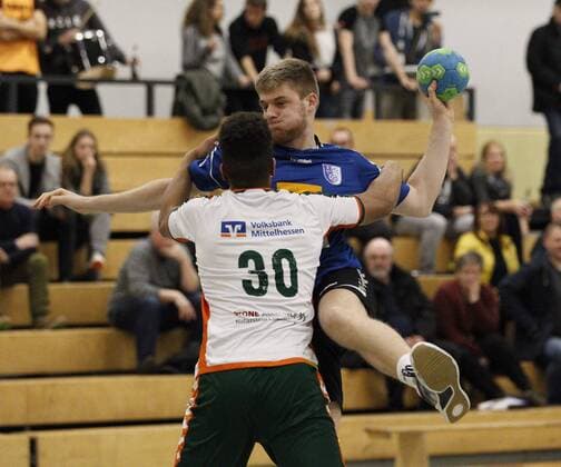 Deutschland - Kelkheim - Münster - 09.12.2017 Handball - Hessen - Oberliga - Herren Saison 2017 2018 TSG Münster (blau) - HSG Dutenhofen Münchholzhausen II (ws) v.l. Maduwuike Okpara (Dutenhofen), Bastian Schwarz (Münster) TSG Münster - HSG Dutenhofen Münchholzhausen II