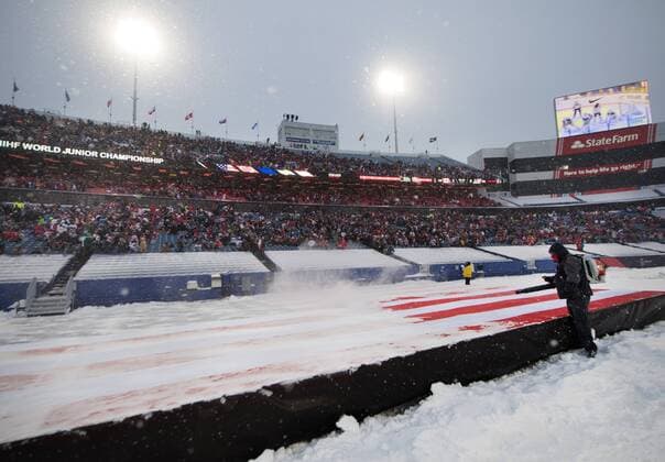 Eishockey, Junioren WM, Outdoor, USA - Kanada 171229 En funktionär blaser bort snö med en lövblas fran en amerikansk flagga i periodpausen av ishockeymatchen i JVM mellan Kanada och USA den 29 december 2017 i Buffalo. Copyright: JOELxMARKLUND BB171229JM053
