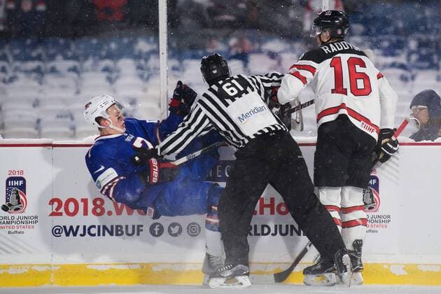 171229 USA:s Brady Tkachuk trycks ned av en linjedomare som gar mellan honom och Kanadas Taylor Raddysh under ishockeymatchen i JVM mellan Kanada och USA den 29 december 2017 i Buffalo. Copyright: JOELxMARKLUND BB171229JM102