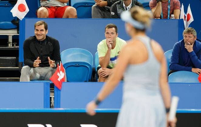 ROGER FEDERER sitzt lachend in der Spielerloge und zeigt BELINDA BENCIC (unscharf im Vordergrund) das ihr Ball im Aus war, ganz rechts Trainer Ian Hughes, Mixed Doubles Copyright: xJuergenxHasenkopfx