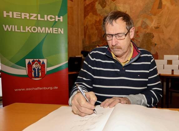 Deutschland, Aschaffenburg, Rathaus, 05.02.2018, Empfang fuer 40 Jahre Handball-Weltmeister von 1978 Bild: Arnult Meffle trägt sich in das Goldene Buch der Stadt Aschaffenburg ein Copyright: HMBxMedia xHeikoxBecker