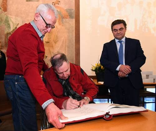 05.02.2018, xjhx, Handball, Empfang der Weltmeister von 1978 in Aschaffenburg, emspor v.l. Joachim Deckarm trägt sich ins goldene Buch der Stadt Aschaffenburg ein, Oberbürgermeister der Stadt Aschaffenburg Klaus Herzog Aschaffenburg