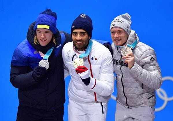 Silver medalist Sweden s Sebastian Samuelsson (L), gold medalist France s Martin Fourcade (C) and bronze medalist Germany s Benedikt Doll pose together during the medal ceremony for Biathlon Men s 12.5km Pursuit at the medal s plaza during the Pyeongchang 2018 Winter Olympics in Pyeongchang, South Korea, on February 13, 2018.  OLY20180213368 KEVINxDIETSCH