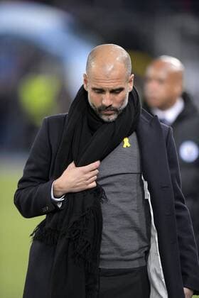 13.02.2018, Fussball UEFA Champions League 2017 2018, Achtelfinale, FC Basel - Manchester City, im St-Jakobs-Park Stadion in Basel (Schweiz). Trainer Pep Guardiola (Manchester City) zeigt beim Gang zur Bank seine Politische Gesinnung vor der versammelten Sportpresse, TV und Fotografen indem er extra unauffällig seinen Schal zur Seite zieht um die Gelbe Schleife auf seiner Brust sichtbar werden zu lassen. Die Gelbe Schleife ist ein Symbol für Solidarität und Unterstützung mit den inhaftierten Politikern und Aktivisten der Unabhängigkeitsbewegung Kataloniens. In Katalonien ist ihre Bedeutung hochpolitisch. Die Schleife wird von vielen Katalanen getragen.