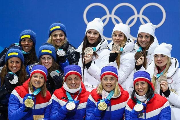 PYEONGCHANG, SOUTH KOREA - FEBRUARY 18, 2018: Gold medalists Ingvild Flugstad Oestberg, Astrid Uhrenholdt Jacobsen, Ragnhild Haga, and Marit Bjoergen (L-R front) of Norway, silver medalists Anna Haag, Ebba Andersson (L-R 2nd row), Charlotte Kalla, Stina Nilsson (L-R 3rd row) of Sweden, and bronze medalists, Olympic Athletes from Russia Anna Nechaevskaya, Anastasia Sedova, Yulia Belorukova, Natalia Nepryaeva (R-L back) pose at a victory ceremony for the ladies cross-country skiing 4x5km relay race at the 2018 Winter Olympic Games Olympische Spiele Olympia OS at the Alpensia Cross-Country Skiing Centre. Valery Sharifulin TASS TS0747CA
