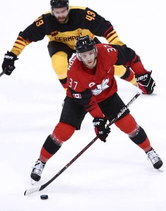 GANGNEUNG, SOUTH KOREA â€“ FEBRUARY 23, 2018: Canada s Mat Robinson (front) and Germany s Gerrit Fauser in action in their men s semifinal Ice hockey Eishockey match during the 2018 Winter Olympic Games Olympische Spiele Olympia OS at the Gangneung Hockey Centre. Valery Sharifulin TASS  TS075756