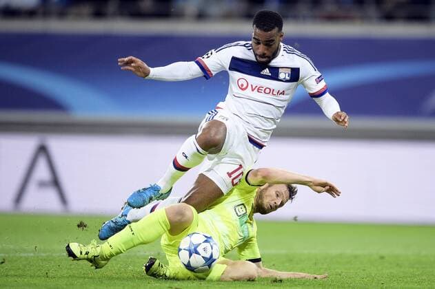 - GENT, BELGIUM: Lyon s Alexandre Lacazette and Gent s Lasse Nielsen fight for the ball during the first game in the group stage of the Uefa Champions League competition, in group H, between Belgian first league soccer team KAA Gent and Olympique Lyon, in Gent, Wednesday 16 September 2015. YORICKxJANSENS x85280468x