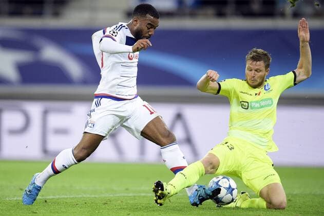 - GENT, BELGIUM: Lyon s Alexandre Lacazette and Gent s Lasse Nielsen fight for the ball during the first game in the group stage of the Uefa Champions League competition, in group H, between Belgian first league soccer team KAA Gent and Olympique Lyon, in Gent, Wednesday 16 September 2015. YORICKxJANSENS x85280479x