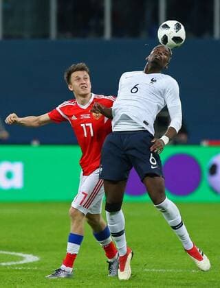 ST PETERSBURG, RUSSIA - MARCH 27, 2018: Russia s Fyodor Smolov (L) and France s Paul Pogba fight for the ball in their friendly football match at Saint Petersburg Stadium. Peter Kovalev TASS  TS079A07