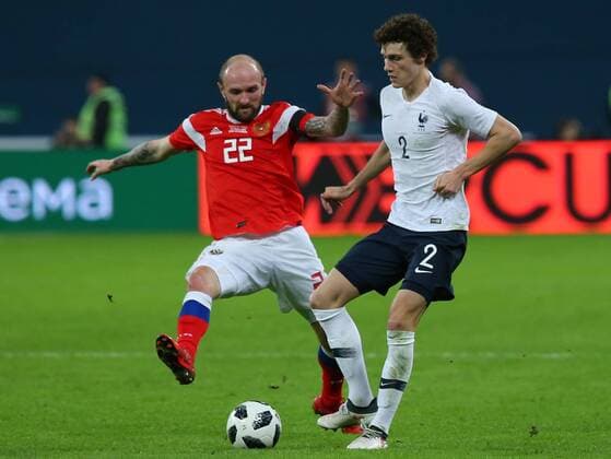 ST PETERSBURG, RUSSIA - MARCH 27, 2018: Russia s Konstantin Raush (L) and France s Benjamin Pavard fight for the ball in their friendly football match at Saint Petersburg Stadium. The French team won the game 3-1. Peter Kovalev TASS  TS079A2F