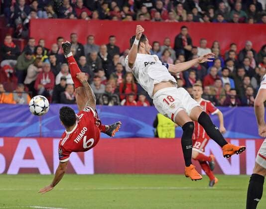 03.04.2018, Fussball UEFA Champions League 2017 2018, Viertelfinale, FC Sevilla - FC Bayern München, im Stadion Ramon Sanchez Pizjuan, Sevilla (Spanien). v.li: Thiago (FC Bayern München) mit Seitfallzieher, gegen Sergio Escudero (FC Sevilla).
