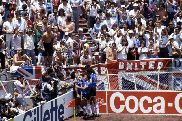 IMAGO Iconic Moments, Fußball FIFA World Cup WM Weltmeisterschaft Fussball - Mexico 1986 22.6.1986, Estadio Azteca, Mexico, D.F. Quarter-final Argentina v England. Diego Maradona celebrates after scoring the greatest goal the World Cup has ever seen, 2-0 against England. English fans in the stand don t seem to agree. Noxthirdxpartyxsales  (75038369)