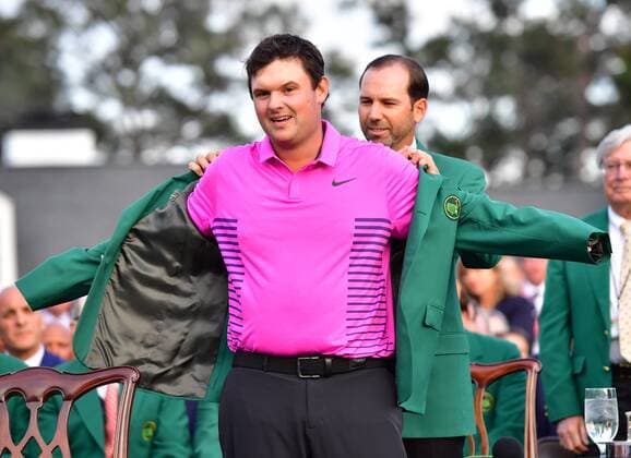 Patrick Reed is presented the green jacket by 2017 champion Sergio Garcia after Reed won the the 2018 Masters Tournament at the Augusta National Golf Club in Augusta, Georgia, on April 8, 2018. Reed wins his first major and the 2018 Masters with a score of 15-under-par.  AUG20180408321 KEVINxDIETSCH