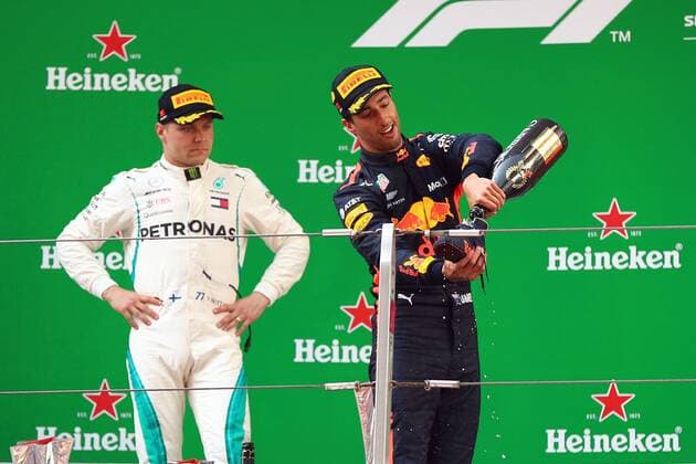 Australian F1 driver Daniel Ricciardo of Red Bull Racing, right, pours champagne into his shoe on the podium after winning the 2018 Formula One Chinese Grand Prix at the Shanghai International Circuit in Shanghai, China, 15 April 2018. Daniel Ricciardo charged from sixth to score a stunning first win of the 2018 Formula 1 season as Max Verstappen and Sebastian Vettel collided in a wild Chinese Grand Prix. Bottas and Vettel were locked in their own battle for the win until Ricciardo and Verstappen pitted again for fresh, soft tyres during a safety car period just after the halfway mark as their rivals stayed on mediums. Ricciardo then overtook his team-mate, Lewis Hamilton and Vettel in quick succession before executing a stunning pass on Bottas into the tight Turn 6 right-hander for the victory. Daniel Ricciardo storms to Chinese Grand Prix victory for Red Bull 
