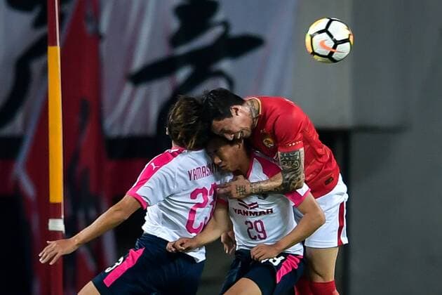 Zhang Linpeng, right, heads the ball against players of Japan s Cerezo Osaka FC in their Group G match during the 2018 AFC Champions League in Guangzhou city, south China s Guangdong province, 17 April 2018. Brazilian striker Alan Carvalho scored twice in the second half to help Guangzhou Evergrande beat the visiting side Cerezo Osaka from Japan 3-1 in a Group G game, final round of the AFC Champions League group stage on Tuesday night. After this game, Guangzhou Evergrande remained unbeaten in this group, earning 12 points and place the first to progress to the knock-out stage of the AFC Champions League, while Buriram United from Thailand managed a 1-0 win over home team Jeju United from South Korea and secured another place in the knock-out stage. Huang Bowen broke the deadlock for Guangzhou Evergrande early in the fifth minute, as the 30-year-old midfielder received the pass from Li Xuepeng, got away from defenders in the penalty area and scored the opening goal. Guangzhou Evergrande beat Cerezo Osaka 3-1 in AFC Champions League  20180417_71136