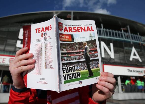 26th April 2018, Emirates Stadium, London, England; UEFA Europa League football, semi final, 1st leg, Arsenal versus Atletico Madrid; Arsenal fan reading todays official match day programme featuring Arsenal manager Arsene Wenger on the front cover  ActionPlus12017153