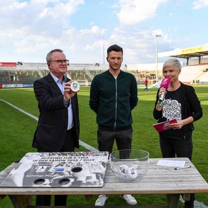 v.li.: Ziehungsleiter Manfred Schnieders (Vorsitzender des DFB-Spielausschusses) zeigt den ausgelosten dritten Direktaufsteiger zur Dritten Liga der Saison 2018 19 - die Regionalliga West, Losfee Benjamin Lauth (Ex-Nationalspieler) Telekom Moderatorin Anett Sattler, Fussball, 3. Liga, SpVgg Unterhaching - VfR Aalen, *** v li Draw Director Manfred Schnieders Chairman of the DFB Gaming Committee shows the third direct promoted to the third league of the season 2018 19 the Regionalliga West Losfee Benjamin Lauth Ex National Team Telekom Sport Moderator Anett Sattler Soccer 3 Liga SpVgg Unterhaching VfR Aalen xslx