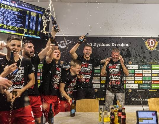 Fußball, 2. Bundesliga, Saison 2017 2018, SG Dynamo Dresden, 32. Spieltag, SG Dynamo Dresden - Fortuna Düsseldorf (28.04.2018), DDV - Stadion, Dresden. Düsseldorfs Trainer Friedhelm Funkel wird von seinen Spielern nach dem Aufstieg in die Bundesliga während der Pressekonferenz mit Bier geduscht. *** Football 2 Bundesliga Season 2017 2018 SG Dynamo Dresden 32 Matchday SG Dynamo Dresden Fortuna Dusseldorf 28 04 2018 DDV Stadion Dresden Dusseldorf coach Friedhelm Funkel is showered by his players after the promotion to the Bundesliga during the press conference with beer RM001