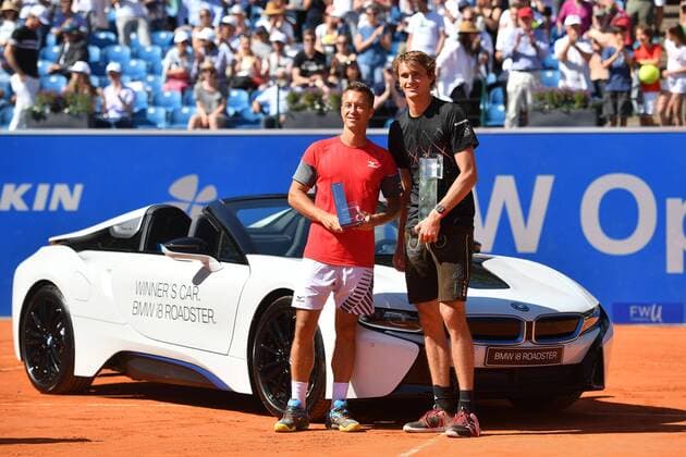 v.re:Alexander ZVEREV (GER) in Lederhose und mit dem Siegerpokal und sein Gegner Philipp KOHLSCHREIBER posieren vor dem Sonderpreis-einem BMW i8 Roadster,Cup,Trophaee,Siegerehrung. FINALE. Tennis BMW Open 2018 am 06.05.2018 in Muenchen.