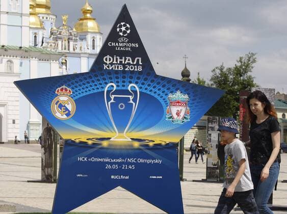 May 12, 2018 - Kiev, Ukraine - People walk past a large sign showcasing the logo for the 2018 UEFA Champions League Final in Kiev, Ukraine, 12 May, 2018. Kiev is preparing for the 2018 UEFA Champions League Final which will be played at the NSC Olimpiyskiy Stadium on May 26, 2018 and for the 2017-18 UEFA Women s Champions League final which will be played at Valeriy Lobanovskiy Dynamo Stadium on 24 May. 2018 UEFA Champions League Final in Kiev  - ZUMAn230 20180512_zaa_n230_566 Copyright: xStrx