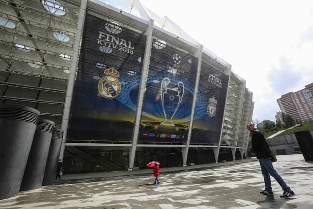 May 14, 2018 - Kiev, Ukraine - A kid under the umbrella walk past NSC Olimpiyskiy Stadium covered with banners for the Champions League in Kyiv, Ukraine, May 14, 2018. Kyiv prepares to host UEFA Women s Champions League final between Wolfsburg and Lyon at Valeriy Lobanovskiy Dynamo Stadium on 24 May, 2018 and the UEFA Champions League final match between Real Madrid and Liverpool at NSC Olimpiyskiy Stadium on Saturday 26 May, 2018. Kyiv prepares NSC Olimpiyskiy for UCLF  - ZUMAn230 20180514_zaa_n230_685 Copyright: xSergiixKharchenkox