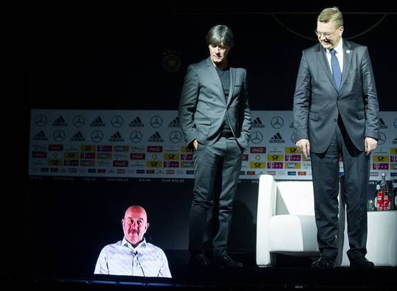 Joachim LOEW (mi., Löw, Jogi, Bundestrainer GER) und Reinhard Dieter GRINDEL (re., DFB-Praesident) beobachten wie die 3D Projektion von Stanislaw TSCHERTSCHESSOW (Trainer RUS) im Boden versinkt, ganze Figur, Kaderbekanntgabe der deutschen Nationalmannschaft (GER) vor der WM 2018, im Fussballmuseum in Dortmund am 15.05.2018. Â