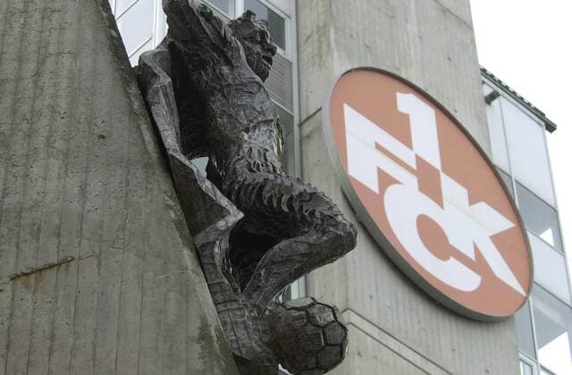 Im Betzenbergstadion in Kaiserslautern wird mit Hochdruck am Dienstag (3.2.2004) an der neuen Tribüne gearbeitet. Den Teufel am Eingang stört das wenig. Kaiserslauterns Betzenberg wird Austragungsort der FIFA Fußball-Weltmeisterschaft 2006 in Deutschland sein und ist die Heimstätte des 1. FC Kaiserslautern in der Fußball-Bundesliga .