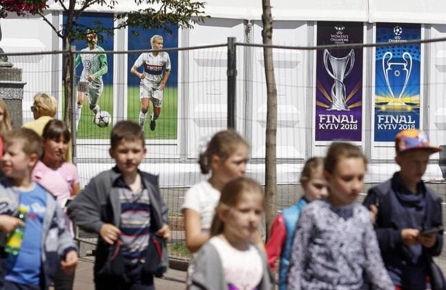 May 18, 2018 - Kiev, Ukraine - Children walk in front of the UEFA Champions League Final 2018 logo, in center of Kiev, Ukraine, on 18 May 2018. Real Madrid will face Liverpool FC in the UEFA Champions League final at the NSC Olimpiyskiy stadium in Kiev on 26 May 2018. UKRAINE UEFA CHAMPIONS LEAGUE FINAL 2018 - ZUMAg194 20180518_zap_g194_002 Copyright: xSergxGlovnyx