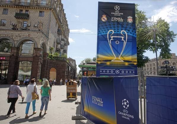 May 18, 2018 - Kiev, Ukraine - People walk in front of the UEFA Champions League Final 2018 logo, in center of Kiev, Ukraine, on 18 May 2018. Real Madrid will face Liverpool FC in the UEFA Champions League final at the NSC Olimpiyskiy stadium in Kiev on 26 May 2018. UKRAINE UEFA CHAMPIONS LEAGUE FINAL 2018 - ZUMAg194 20180518_zap_g194_003 Copyright: xSergxGlovnyx