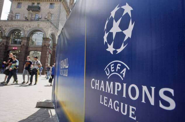 May 18, 2018 - Kiev, Ukraine - People walk in front of the UEFA Champions League Final 2018 logo, in center of Kiev, Ukraine, on 18 May 2018. Real Madrid will face Liverpool FC in the UEFA Champions League final at the NSC Olimpiyskiy stadium in Kiev on 26 May 2018. UKRAINE UEFA CHAMPIONS LEAGUE FINAL 2018 - ZUMAg194 20180518_zap_g194_010 Copyright: xSergxGlovnyx