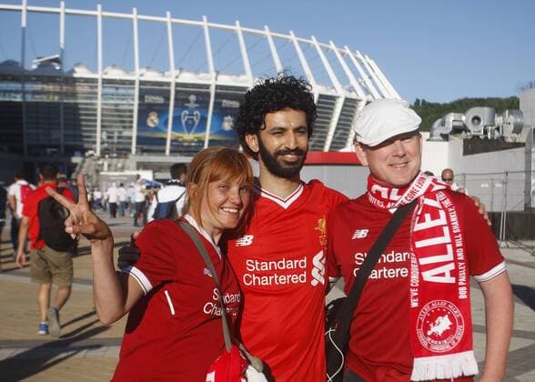 May 26, 2018 - Kiev, Ukraine - Liverpool fans pose for a photo with a man dressed like Liverpool s Mohamad Salah , in front of the NSC Olimpiyskiy stadium in Kiev, Ukraine, 26 May 2018. Real Madrid will face Liverpool FC in the UEFA Champions League final at the NSC Olimpiyskiy stadium on 26 May 2018. Real Madrid vs Liverpool FC, UEFA Champions League final - ZUMAg194 20180526_zap_g194_007 Copyright: xSergxGlovnyx