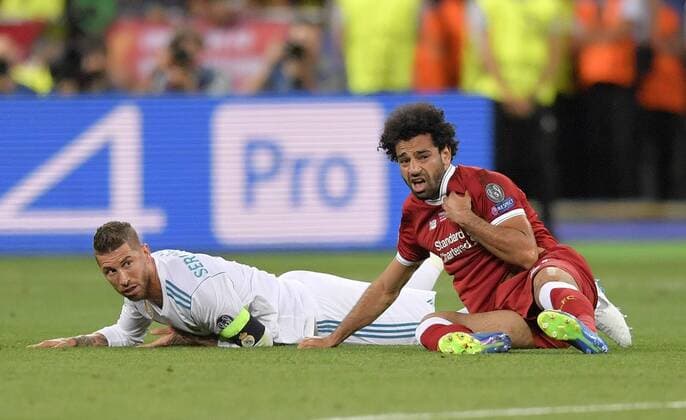 26.05.2018, Fussball UEFA Championsleague Finale 2018, Real Madrid - FC Liverpool, im Olympiastadion Kiew (Ukraine). v.l. Sergio Ramos (Real Madrid) reisst im Zweikampf Mohamed Salah (FC Liverpool) um, der ünglücklich auf die linke Schulter fällt und deswegen verletzt aus dem Spiel gehen muss.